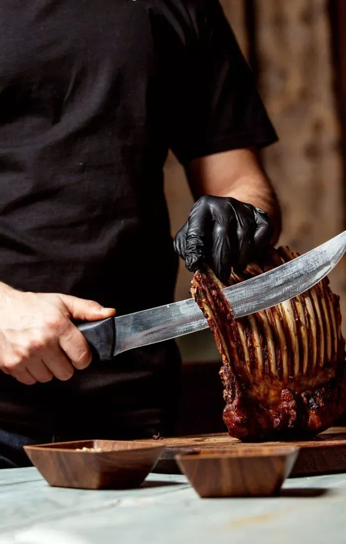 Cocinero cortando la carne a la brasa